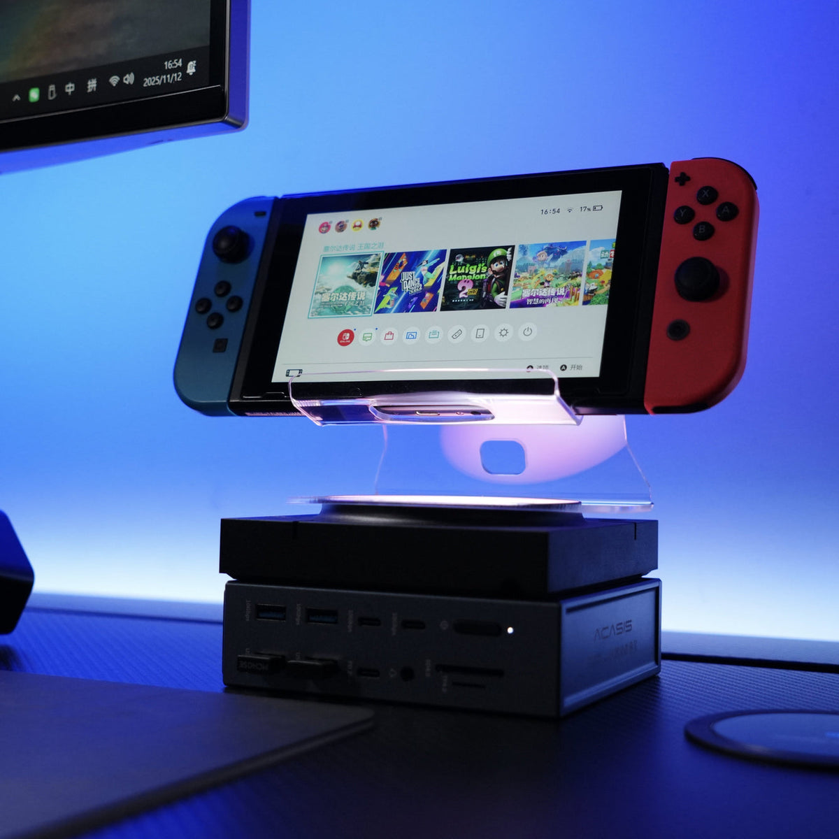 Nintendo Switch console docked on a clear acrylic stand, resting on a black electronic device with multiple ports, set against a blue-lit background.